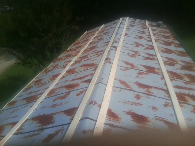 Rusted metal roof panels with new wood purlins before replacement — Storm Damage Roof Repair in Perrinton by Roofing Brothers