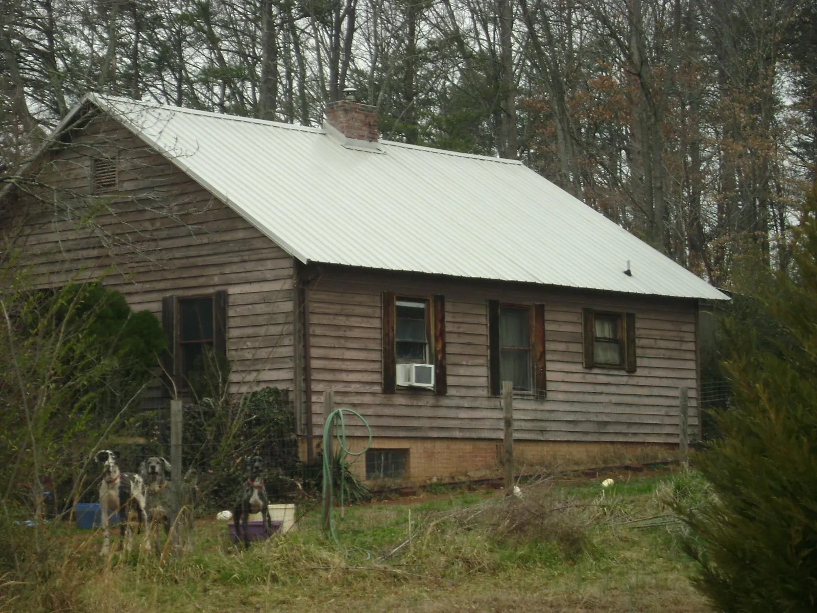 White metal roof on an old wood sided farmhouse, from a Metal Roof Installation job in Perrinton